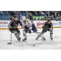 Vancouver Giants defenceman Bowen Byram (left) and centre Jadon Joseph (right) harass a Kamloops Blazer
